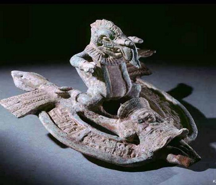 Olmec artifact depicting an unknown being riding a strange vehicle.